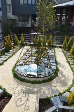 本堂よりも入口近くにある永代供養納骨堂。フェンス沿いには観葉植物のゴールドクレスト、墓石のまわりにはツル科植物のヘデラ・ピッツバーグが植えられている。 本堂よりも入口近くにある永代供養納骨堂。フェンス沿いには観葉植物のゴールドクレスト、墓石のまわりにはツル科植物のヘデラ・ピッツバーグが植えられている。